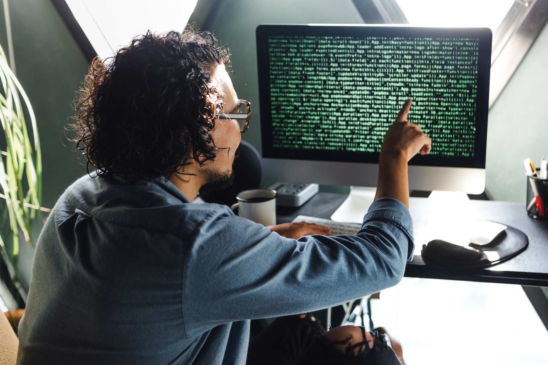 latin man programmer writing program code on desktop computer sitting at the workplace at home in Mexico Latin America, hispanic people